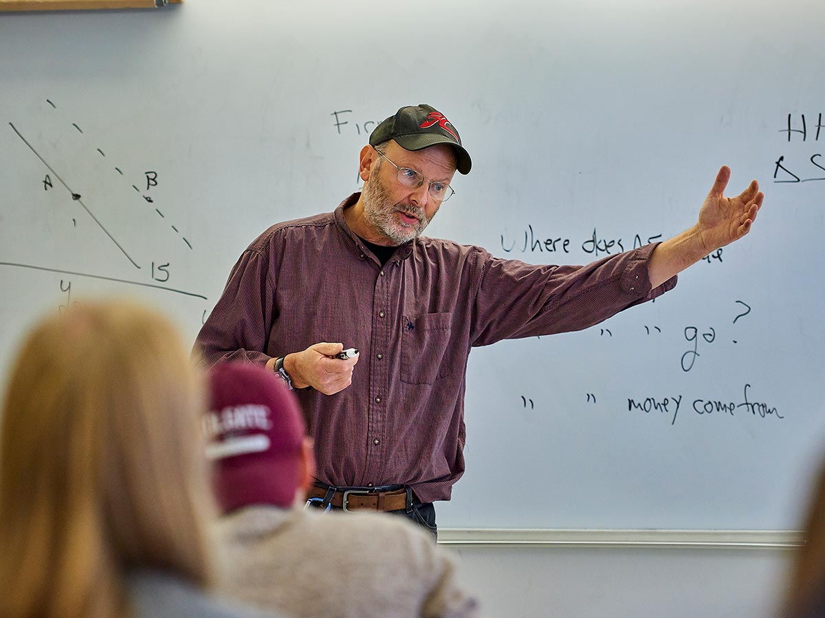 Thomas Michl, Professor Of Economics, teaches in front of a white board