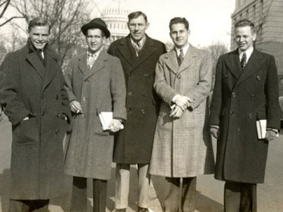 black and white photo of men in winter coats