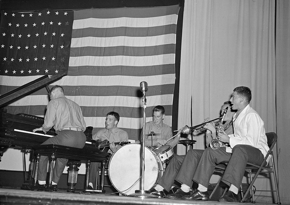 Members of a Marine cadet band perform on stage for student event, 1943