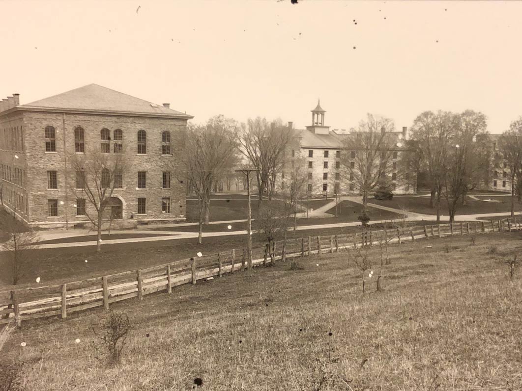 Archival image of Alumni Hall, the Western Edifice, and the Eastern Edifice, as seen from further up the hill