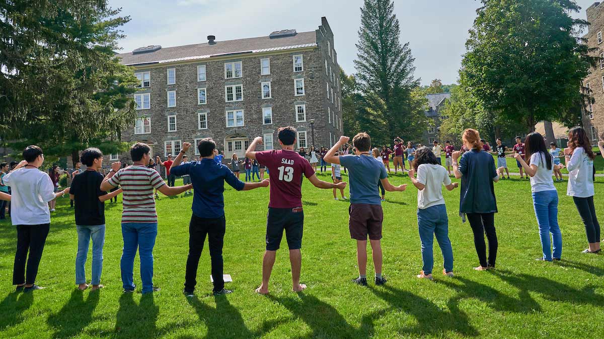 Students linking arms on the academic quad