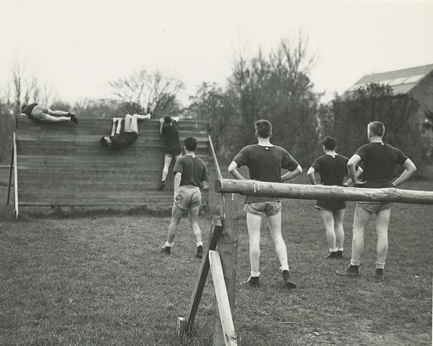 Cadets climb wall on 400-yard commando course, 1943