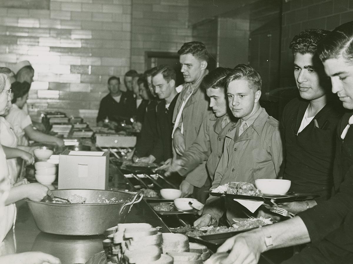 Archival image of male students in a cafeteria line