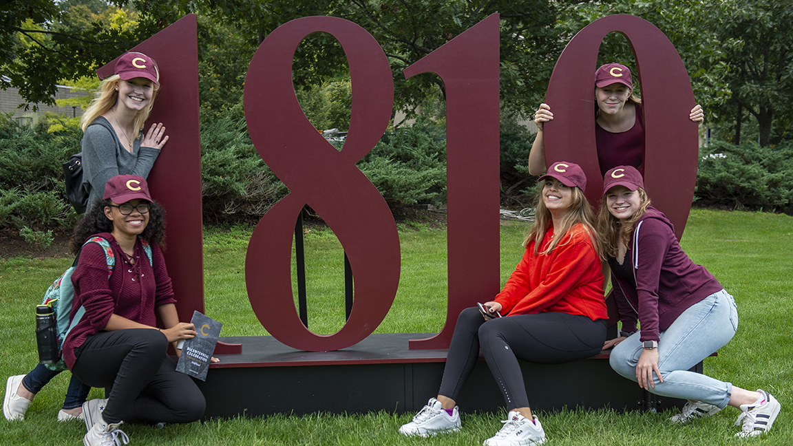 Students pose in front of 1819 statue